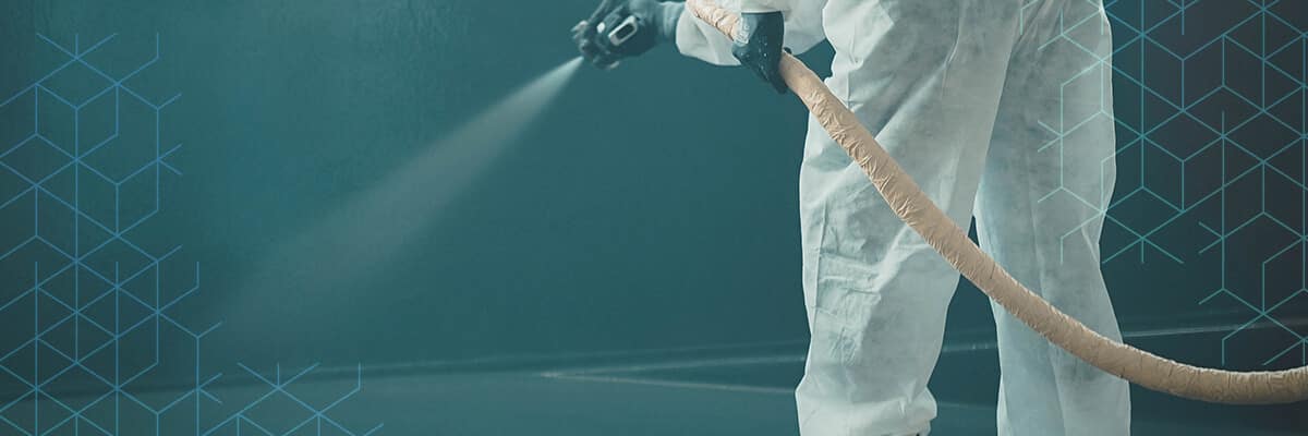 homem com roupa de proteção pintando piso